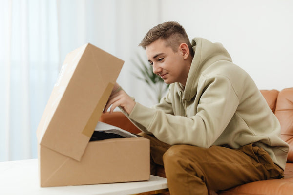 boy wearing a hoodie and looking through box